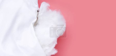Weißes Kissen mit stabiler Polyesterfaser auf rosa Hintergrund.
