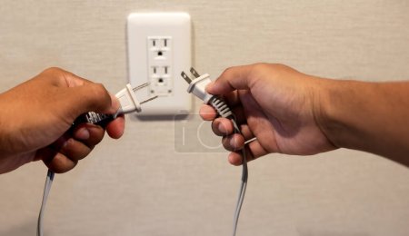 Photo for Hands insert a plug of the phone charger into socket. - Royalty Free Image