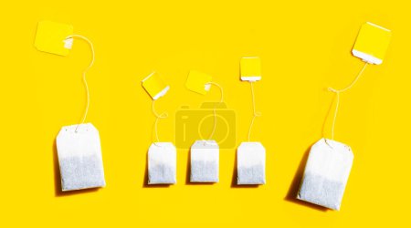 Tea bags on yellow background.