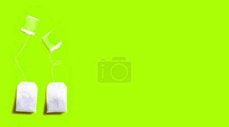 Tea bags on green background.
