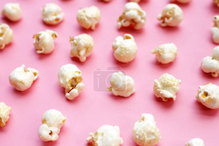 Süßes Popcorn auf rosa Hintergrund.