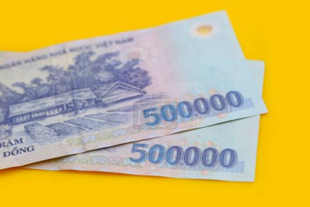 Vietnamese dong banknotes on yellow background.