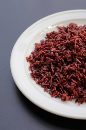 Cooked black berry rice on dark background.