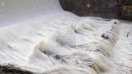 Photo for Shot of water hitting concrete barriers after heavy rainfall. Shot on an overcast day in November.  Long exposure setting is used for a milky water feel. - Royalty Free Image