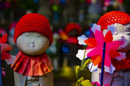 Statue gardienne portant un chapeau rouge le jour. Minato district Tokyo Japon - 07.25.2019 : C'est une vieille statue au sanctuaire traditionnel.