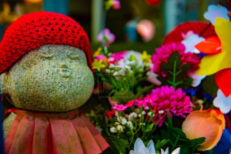 Statuenwächter mit rotem Hut tagsüber. Minato District Tokyo Japan - 25.07.2019: Es ist eine alte Statue am traditionellen Schrein.
