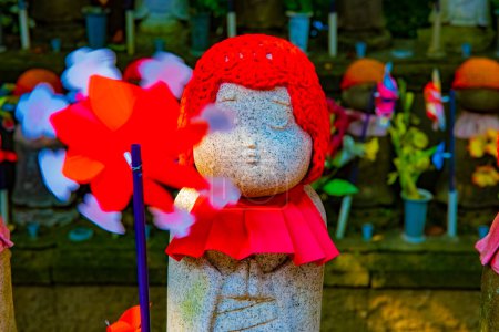 Statuenwächter mit rotem Hut tagsüber. Minato District Tokyo Japan - 25.07.2019: Es ist eine alte Statue am traditionellen Schrein.