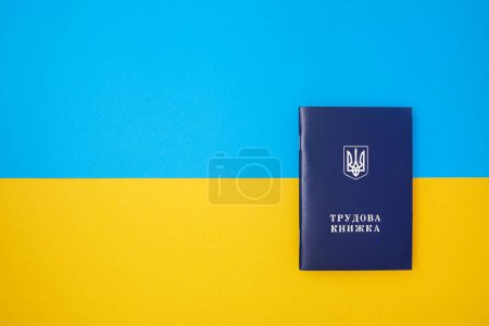 Photo for One blue Ukrainian work book on the Ukrainian national flag in the top view - Royalty Free Image