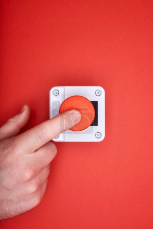 Photo for The hand, which pushes the emergency button at the red background at the top view - Royalty Free Image