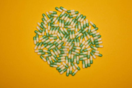 Group of green-yellow capsules in centre of yellow background
