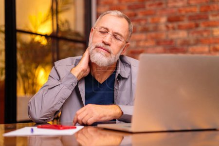 Photo for Worried aged man sit by laptop and try do make payment online. - Royalty Free Image