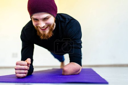Foto de Hombre discapacitado feliz haciendo ejercicios en casa permanecer positivo y fuerte. - Imagen libre de derechos