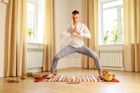 Téléchargez les photos : Pratique du yoga matinal avec des ongles sadhu. mans pied sur le bureau en bois avec des clous métalliques pointus. - en image libre de droit