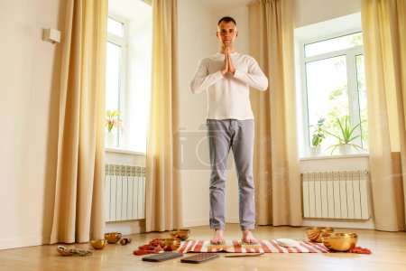 Téléchargez les photos : Pratique du yoga matinal avec des ongles sadhu. mans pied sur le bureau en bois avec des clous métalliques pointus. - en image libre de droit