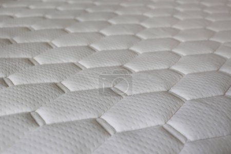 White orthopedic mattress with cell shaped patterns. Hypoallergenic foam matress for proper spinal alignment and pressure point relief. Close up, copy space for text, background.