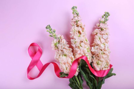 Pink ribbon in the shape of eight as symbol of symbol of women's equality and a bouquet of flowers. International women's day concept. Close up, copy space for text, background.