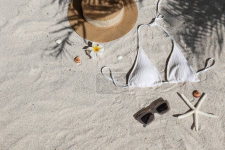 Foto de Vibras de verano. Sombrero de paja, traje de baño y gafas de sol en una playa de arena.. Piso tendido, espacio para copiar, vista superior, fondo. - Imagen libre de derechos