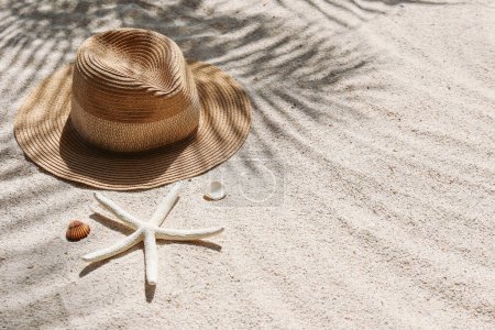 Foto de Vibras de verano. Gorro de paja de ala ancha y gafas de sol en una playa de arena. Copiar espacio para texto. - Imagen libre de derechos