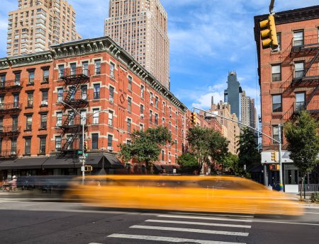 Photo for Yellow taxi speeding down the road through the Hell's Kitchen neighborhood of New York City with motion blur effect - Royalty Free Image