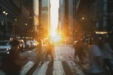 Foto de People walking through a busy crosswalk at Grand Central Station in New York City with sunlight shining in the background - Imagen libre de derechos
