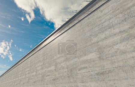 Photo for A massively high concrete security boundary wall topped with barbed wire on a blue sky background - 3D render - Royalty Free Image