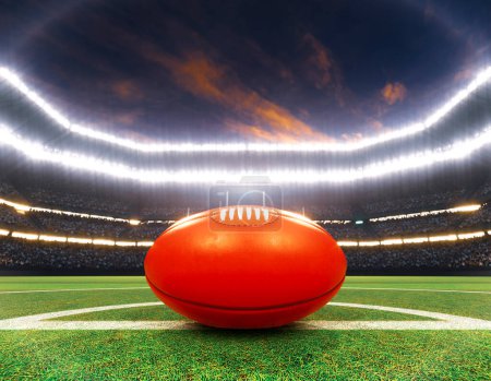 Téléchargez les photos : Une aussie rouge règle la balle sur la ligne centrale d'un stade avec des poteaux sur un terrain d'herbe verte marquée la nuit sous des projecteurs éclairés - rendu 3D - en image libre de droit