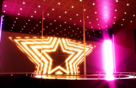 Foto de Un escenario de baile club de striptease vacío con tres polos y un telón de fondo de pantalla led iluminado - 3D render - Imagen libre de derechos