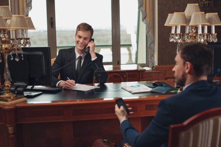 Photo for Receptionist and customer on reception desk talking phone. High quality photo - Royalty Free Image