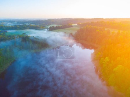 Majestätischer Morgen: Blick aus der Drohne auf einen nebeligen See im Wald bei Sonnenaufgang in Nordeuropa