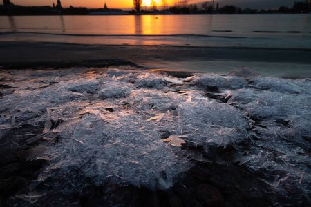 Téléchargez les photos : Un magnifique paysage hivernal au lever du soleil à Riga, capitale de la Lettonie, avec la rivière gelée Daugava. Paysage urbain coloré de l'Europe du Nord. - en image libre de droit