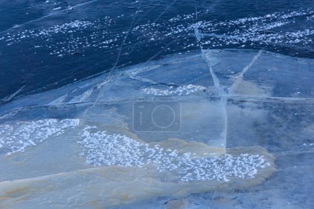 A beautiful cracked ice patterns on the frozen lake surface during winter in Latva. Cold scenery of Northern Europe.