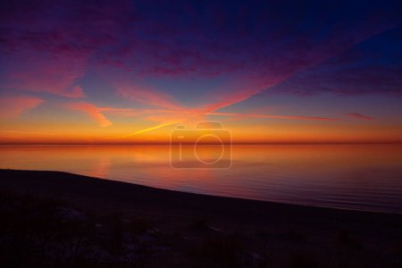 Téléchargez les photos : Un magnifique décor minimaliste d'un coucher de soleil sur la mer Baltique. Paysage de plage coloré du nord de l'Europe. - en image libre de droit