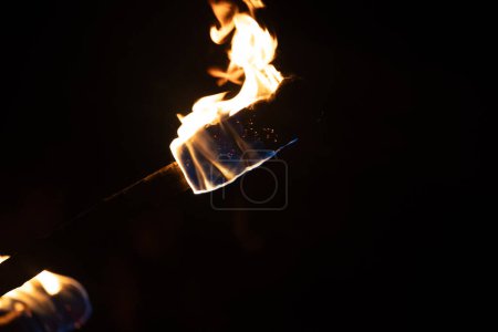 Téléchargez les photos : Un beau gros plan d'une torche brûlante avec des flammes de feu pendant la fête d'été. Feu lumineux dans la nuit. - en image libre de droit