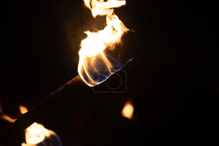 Téléchargez les photos : Un beau gros plan d'une torche brûlante avec des flammes de feu pendant la fête d'été. Feu lumineux dans la nuit. - en image libre de droit
