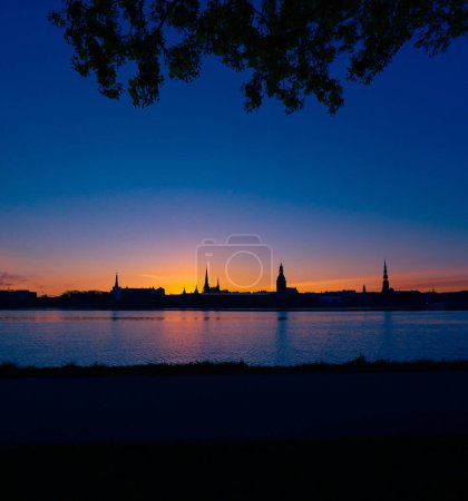 A beautiful city center panorama during summer sunrise of Riga, Latvia. Colorful scenery with building silhouettes against the bright sky.