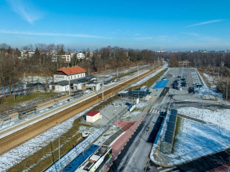 Photo for Newly modernized small railway station in Swoszowice district in Krakow, Poland, for fast city trains. Big park and ride P+R incentive parking lot, bus stop, bicycle shelter. Aerial view in winter - Royalty Free Image
