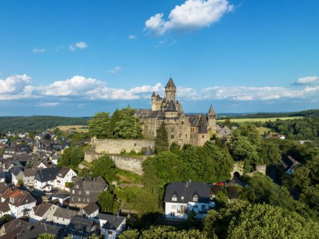 Mittelalterliche Burg im hessischen Braunfels mit vielen späteren Ergänzungen. Luftaufnahme im Sommer vor Sonnenuntergang. Stadt und Wald unten