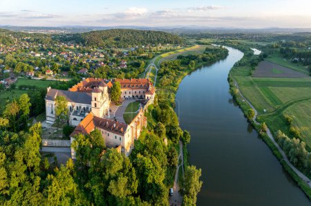 Tyniec near Krakow, Poland. Benedictine abbey, monastery and Baroque church with Gothic presbytery  on the rocky cliff and Vistula River. Aerial view in summer in sunset light