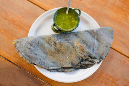 Foto de Fresh blue corn tortillas - quesadilla dish on local market in Oaxaca. Traditional mexican cuisine made of fresh ingredients. - Imagen libre de derechos