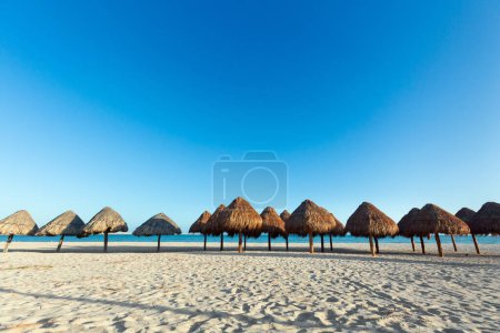 Foto de Hermosa playa de Progreso en México durante el día soleado. Sombrillas naturales en playa blanca y cielo azul. - Imagen libre de derechos