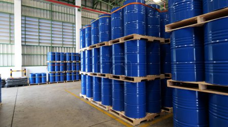Un barril azul En el almacén, los barriles químicos de 200 litros están dispuestos en paletas de madera y esperando la entrega. Tecnología de transporte, industria petrolera y conceptos de industria química