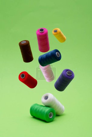 Téléchargez les photos : Différentes bobines de fil de coton à coudre de différentes couleurs flottant. - en image libre de droit