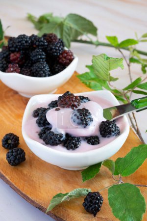 Photo for Wild berries naturally on a wooden cutting board with creamy yogurt - Royalty Free Image