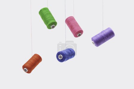 Téléchargez les photos : Différentes bobines de fil de coton à coudre de différentes couleurs flottant. - en image libre de droit