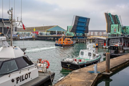 Foto de Poole lifting bridge in raised position as RNLI lifeboat passes through in Poole, Dorset, UK on 13 February 2023 - Imagen libre de derechos