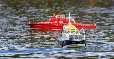 Photo for Close up of a model Pilot Boat - Spitfire - on the water with red model boat in background - Warminster, Wiltshire, UK on 26 February 2023 - Royalty Free Image
