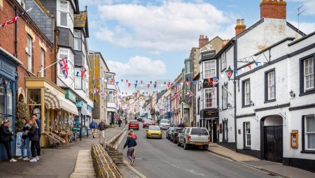 Photo for View looking up Broad Street, decorated with colourful bunting and Union Jack flags in Lyme Regis, Dorset, UK on 7 May 2023 - Royalty Free Image