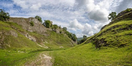 Peveril Castle seen from the Cavedale limestone valley in the High Peak District, Castleton, Derbyshire, UK on 25 July 2023