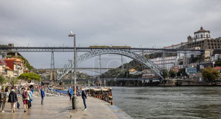 Téléchargez les photos : Métro traversant le pont Luis I sur la rivière Douro à partir du bord de la rivière à Porto, Portugal le 18 octobre 2023 - en image libre de droit