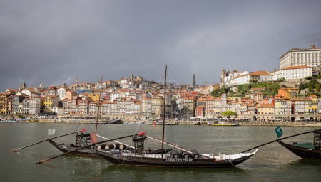 Photo for Historic rabelo boats with port barrels moored opposite Portos's Ribiera waterfront district on the River Douro, Gaia, Porto, Portugal on 18 October 2023 - Royalty Free Image